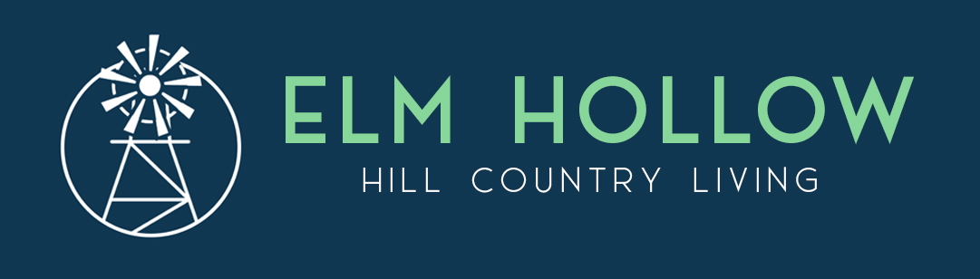 Property entrance sign with windmill logo at Elm Hollow Apartments, Helotes, TX 78023